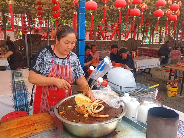 图为：5月18日，返乡创业者热汗古丽·麦合木提和她的姐姐阿伊孜姆古丽·塔西图木尔在温宿县克孜勒镇青年新村经营一家羊杂碎店，正在给顾客制作美食（江凯摄）_副本.jpg